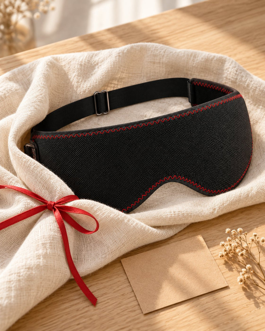 Le masque Lunaeli emballé dans un tissu en lin avec un ruban rouge, à côté d'une carte vierge